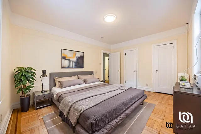 a bedroom with a bed and a potted plant