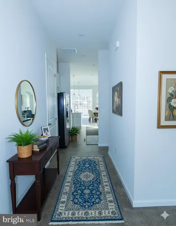a living room with a couch a rug kitchen view and a window