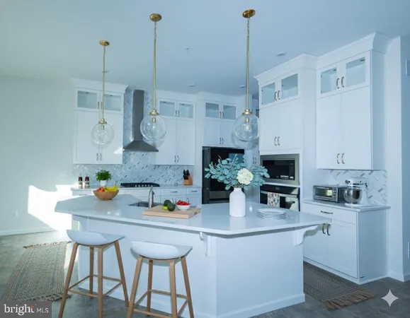 a kitchen with stainless steel appliances a sink a white cabinets and chairs