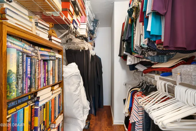a view of walk in closet with clothes and shoes