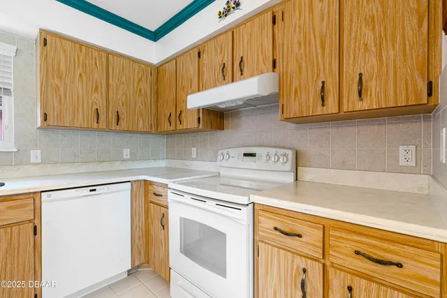 a kitchen with stainless steel appliances granite countertop white cabinets and a stove top oven