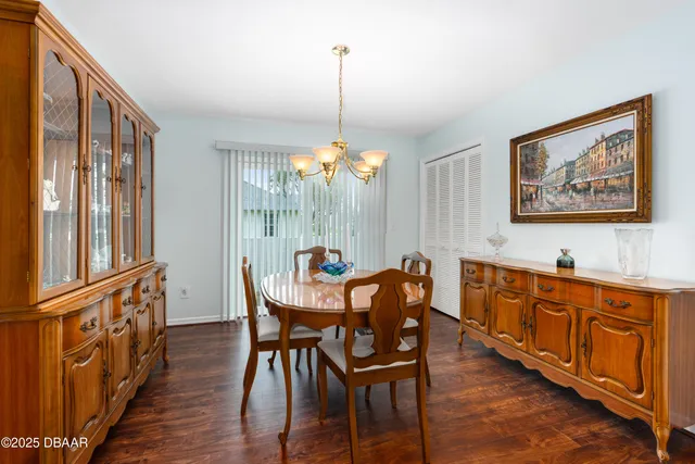 a dining room with furniture a chandelier and wooden floor