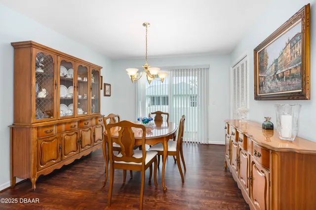 a dining room with furniture a chandelier and wooden floor