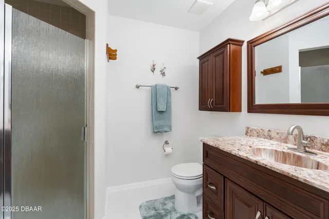 a bathroom with a granite countertop sink toilet and shower