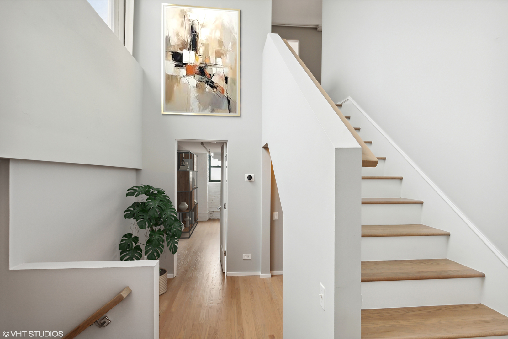 1000 West Washington Boulevard, Unit 513 Chicago, IL 60607 - Photo 11 of 22 a view of staircase with wooden floor and lots of frames on wall