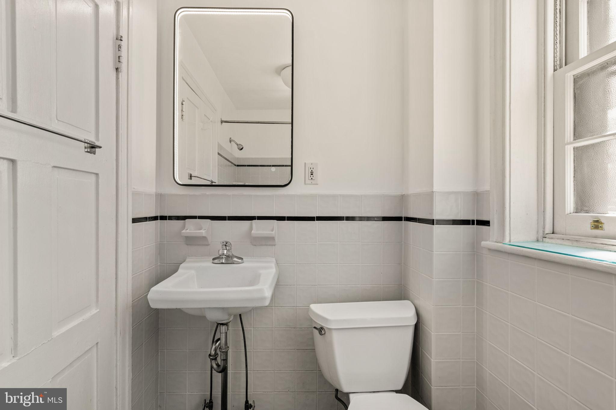 2208 Rittenhouse Square Philadelphia, PA 19103 - Photo 19 of 27 a bathroom with a toilet a sink and mirror