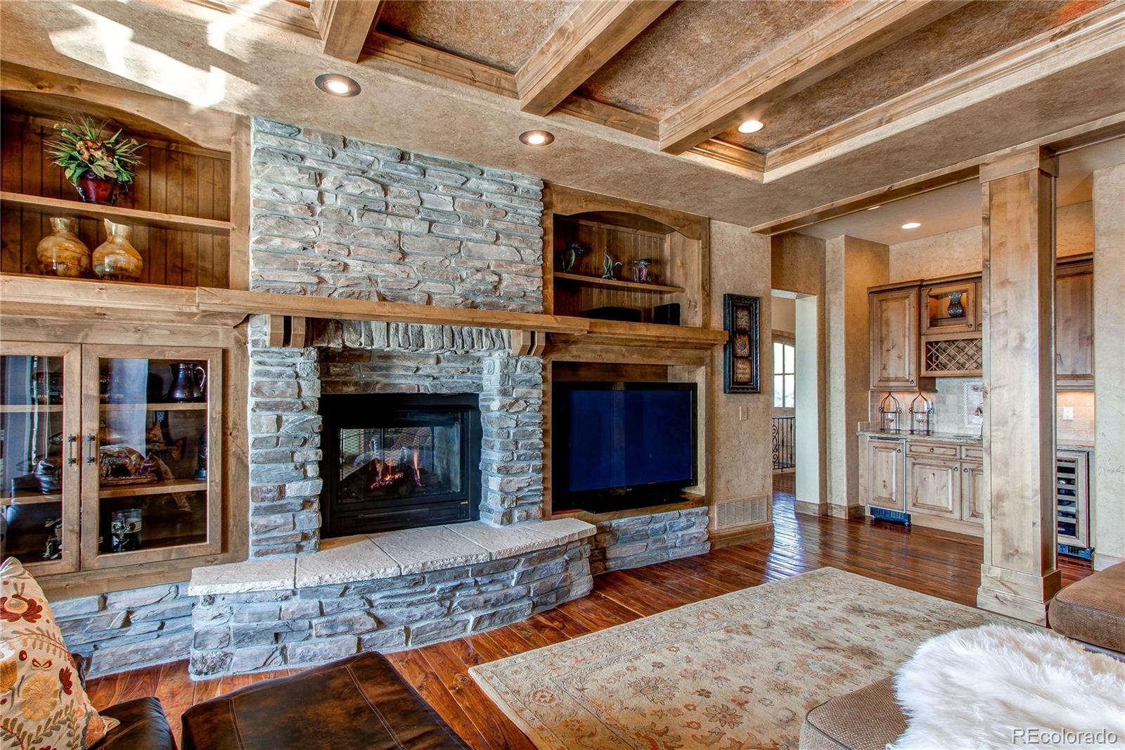 5764 Amber Ridge Drive Castle Pines, CO 80108 - Photo 13 of 50 a living room with furniture a flat screen tv and a fireplace