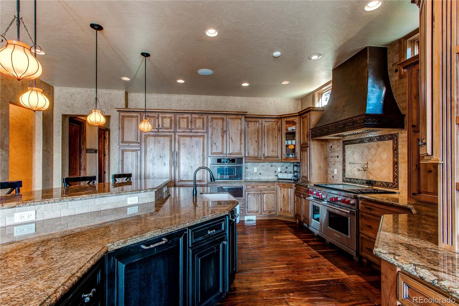 5764 Amber Ridge Drive Castle Pines, CO 80108 - Photo 17 of 50 a kitchen with stainless steel appliances granite countertop a stove a sink and a refrigerator