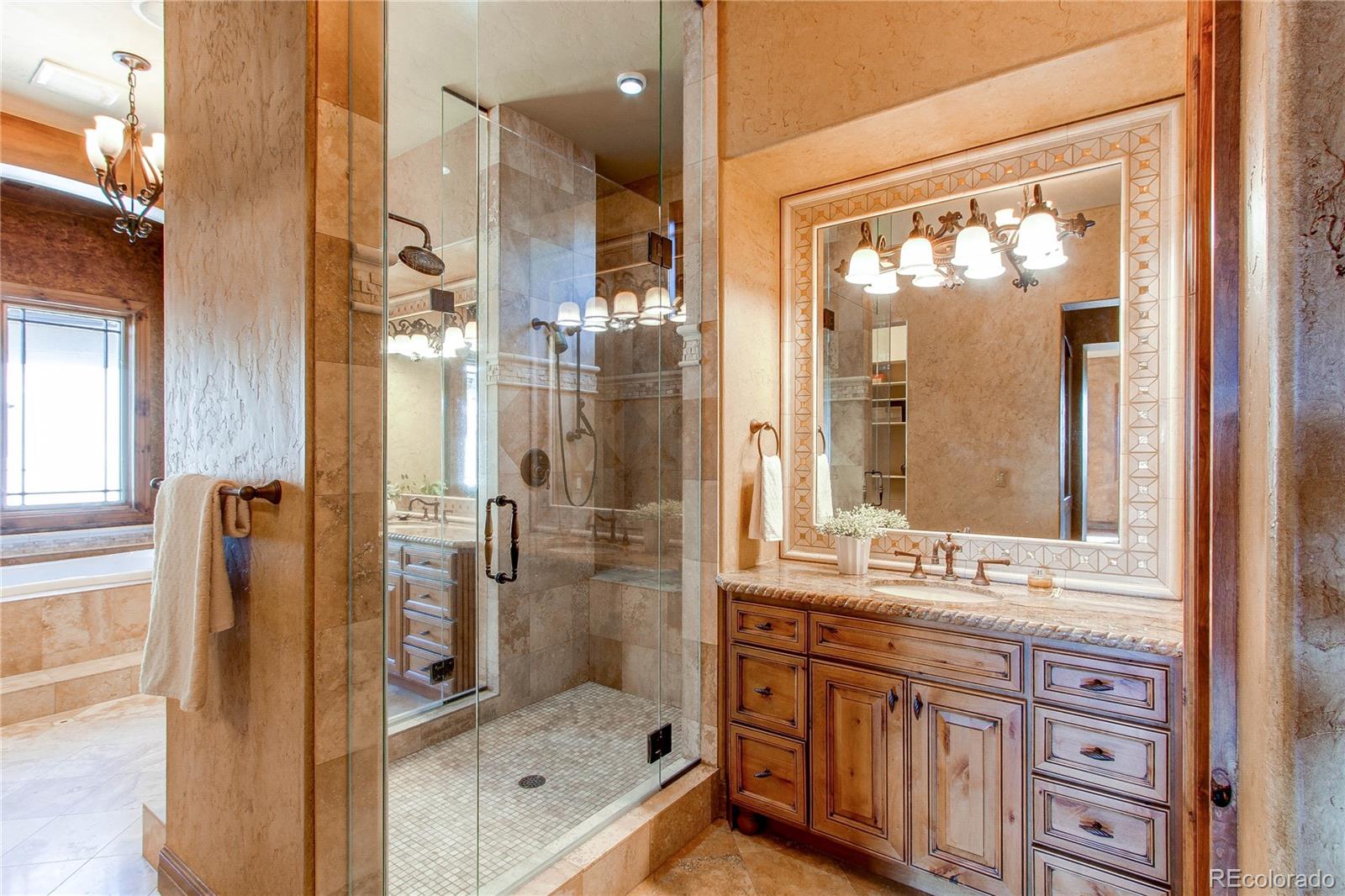 5764 Amber Ridge Drive Castle Pines, CO 80108 - Photo 24 of 50 a bathroom with a shower sink and mirror