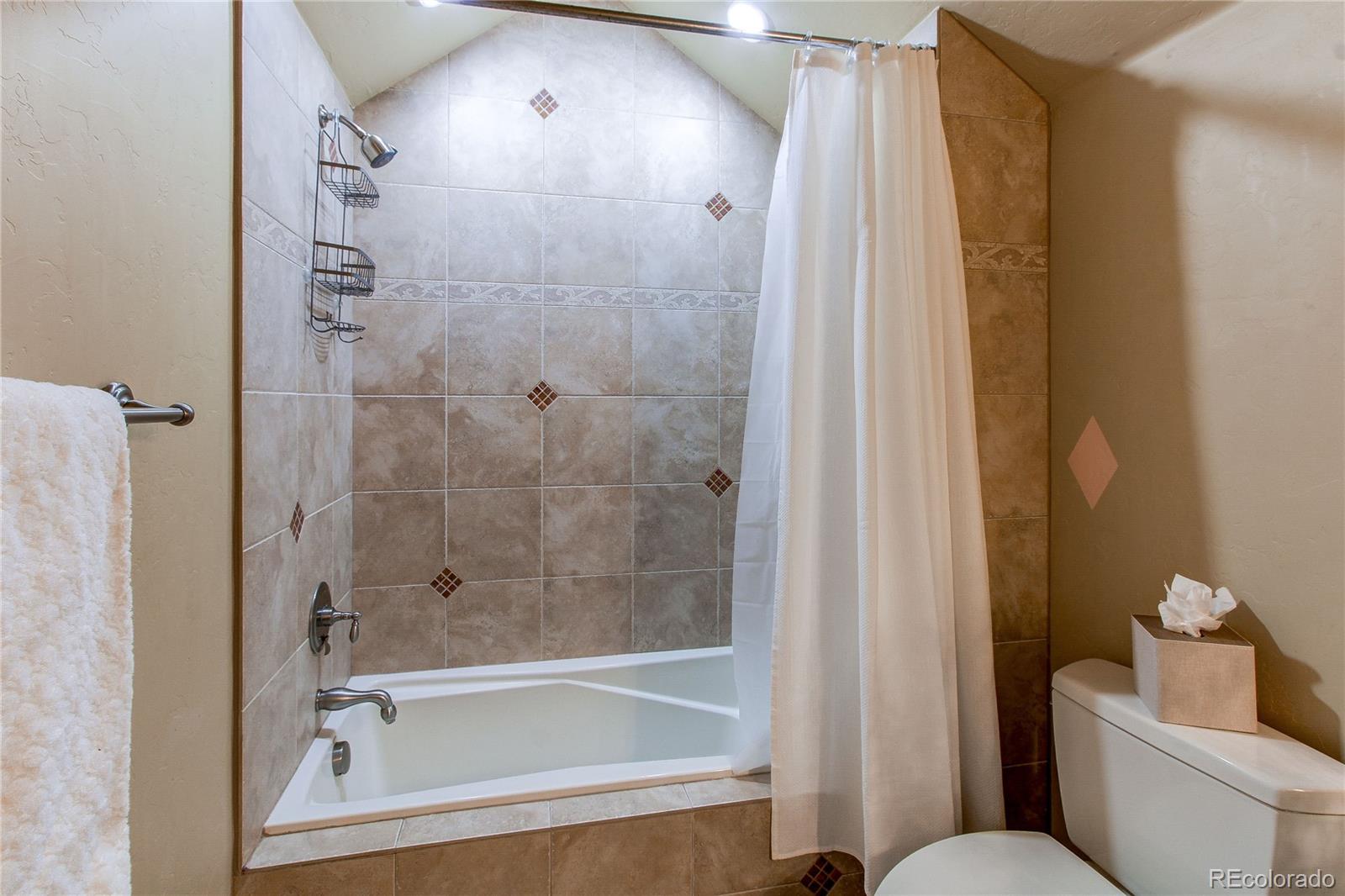 5764 Amber Ridge Drive Castle Pines, CO 80108 - Photo 28 of 50 a bathroom with a bathtub and a shower