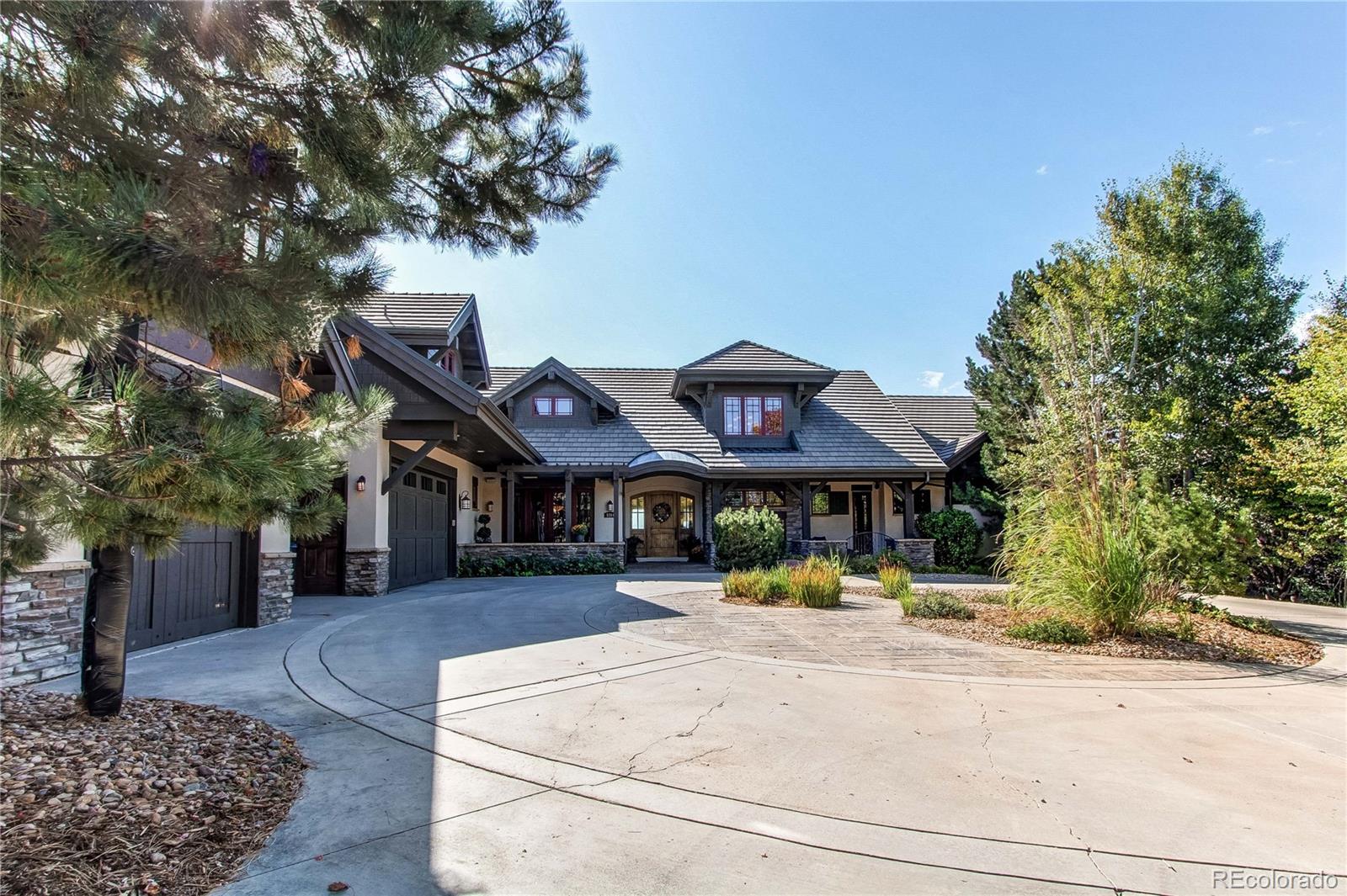 5764 Amber Ridge Drive Castle Pines, CO 80108 - Photo 3 of 50 a view of a white house with a large tree
