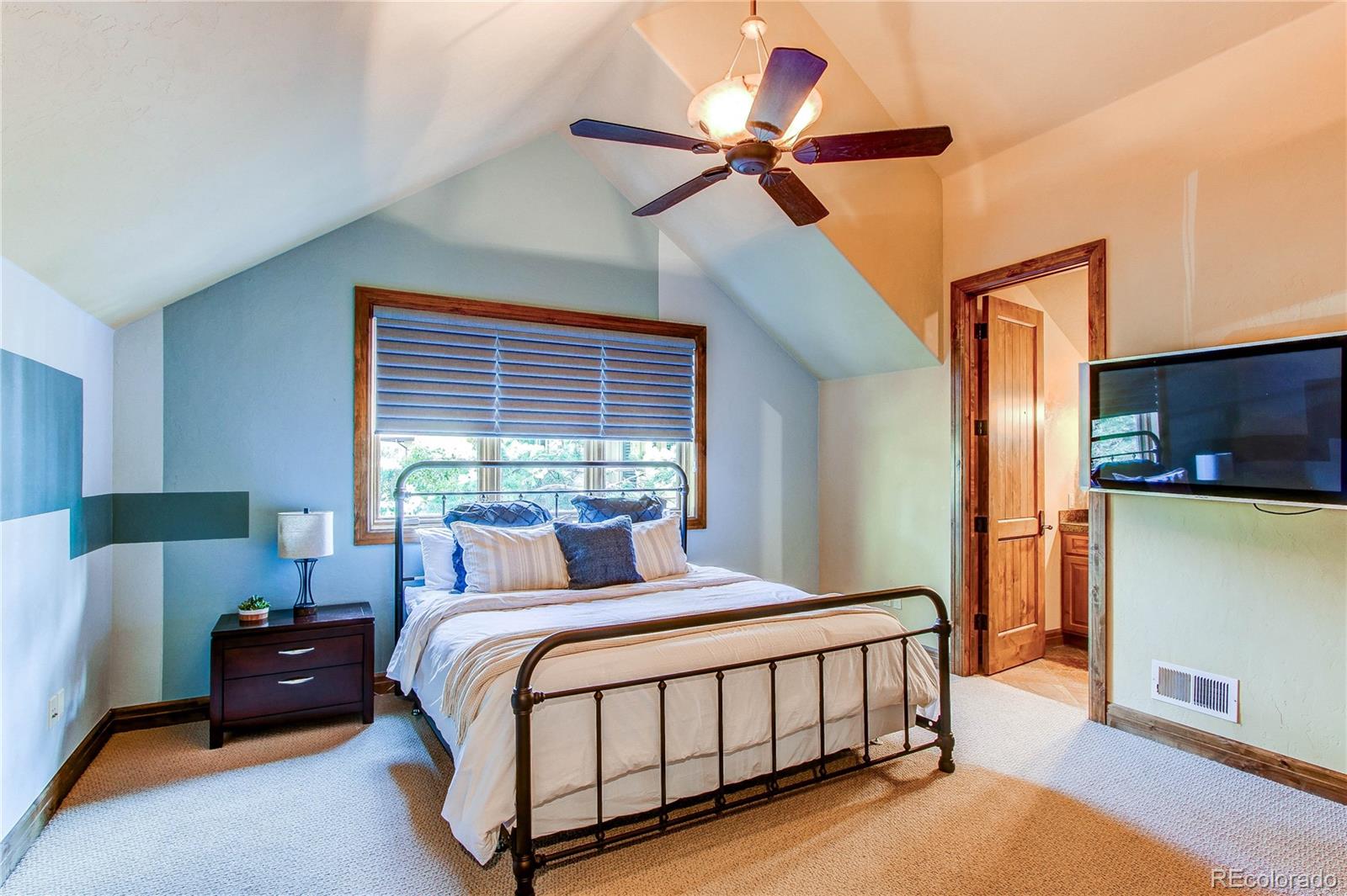 5764 Amber Ridge Drive Castle Pines, CO 80108 - Photo 31 of 50 a bedroom with a bed a window and a chandelier