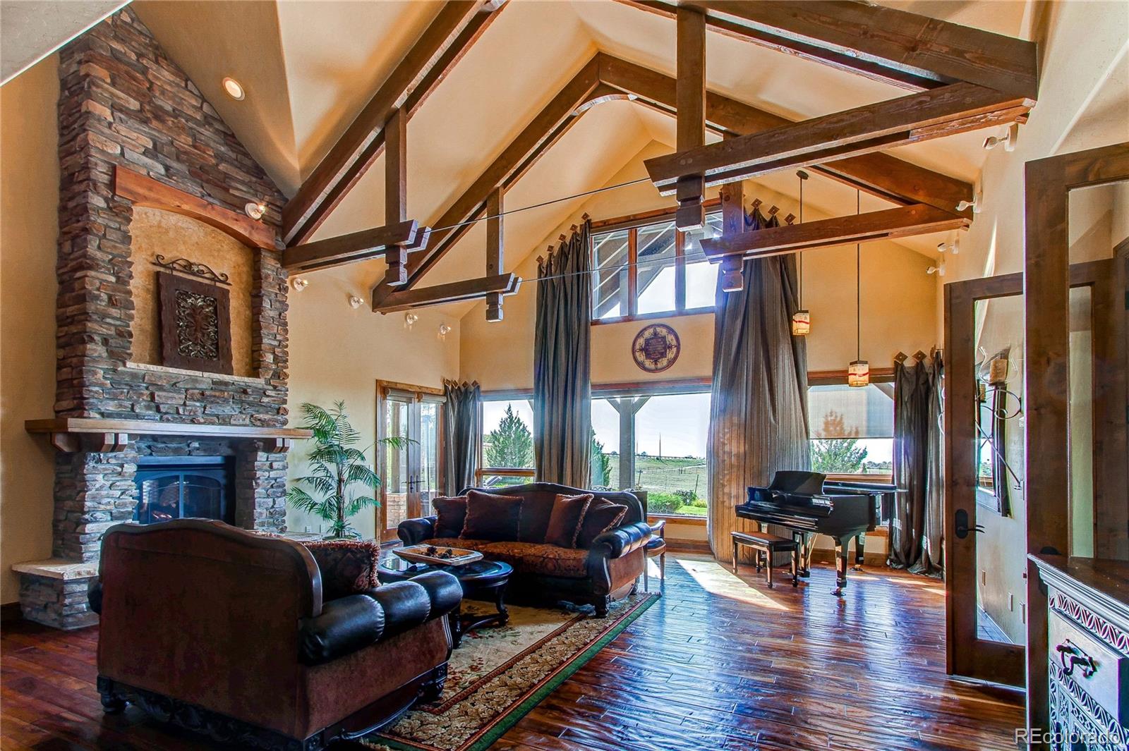 5764 Amber Ridge Drive Castle Pines, CO 80108 - Photo 8 of 50 a living room with furniture a fireplace and a floor to ceiling window