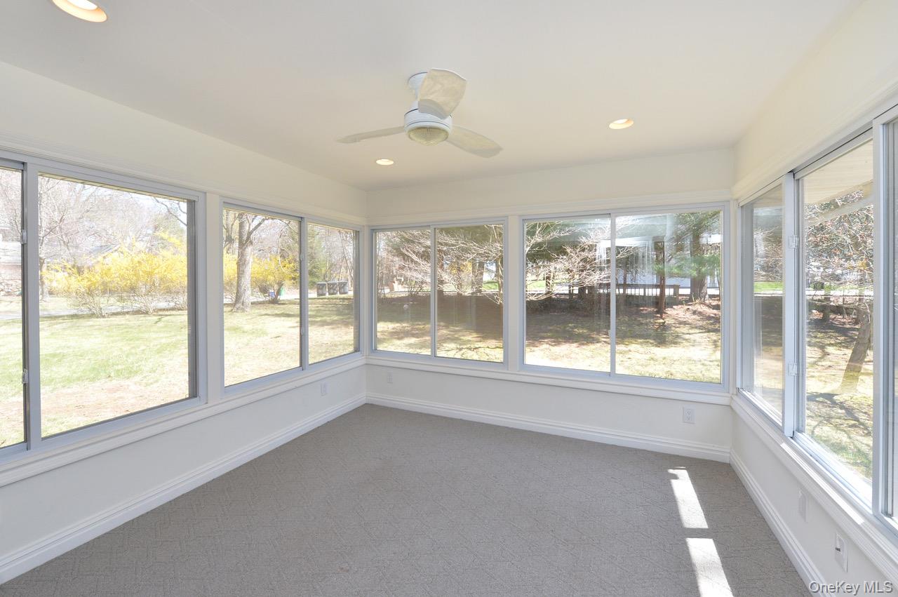 2 Augur Road Airmont, NY 10901 - Photo 9 of 34 a view of an empty room with a large window and a kitchen area with wooden floor