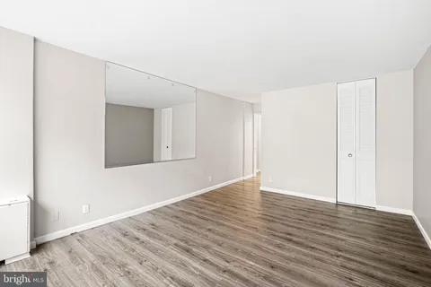 a view of an empty room with wooden floor