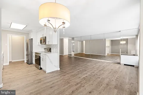 a view of a kitchen with kitchen island wooden floor center island and stainless steel appliances