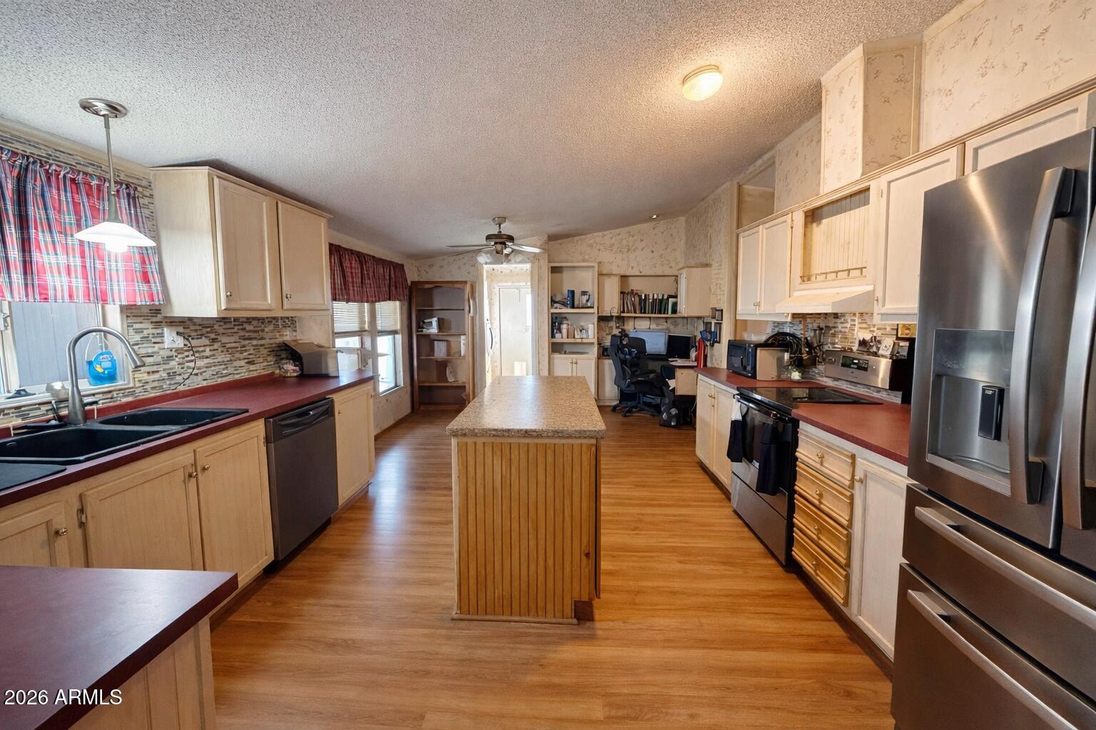 3700 South Tomahawk Road, Unit 99 Apache Junction, AZ 85119 - Photo 4 of 10 a large kitchen with stainless steel appliances sink a microwave and cabinets
