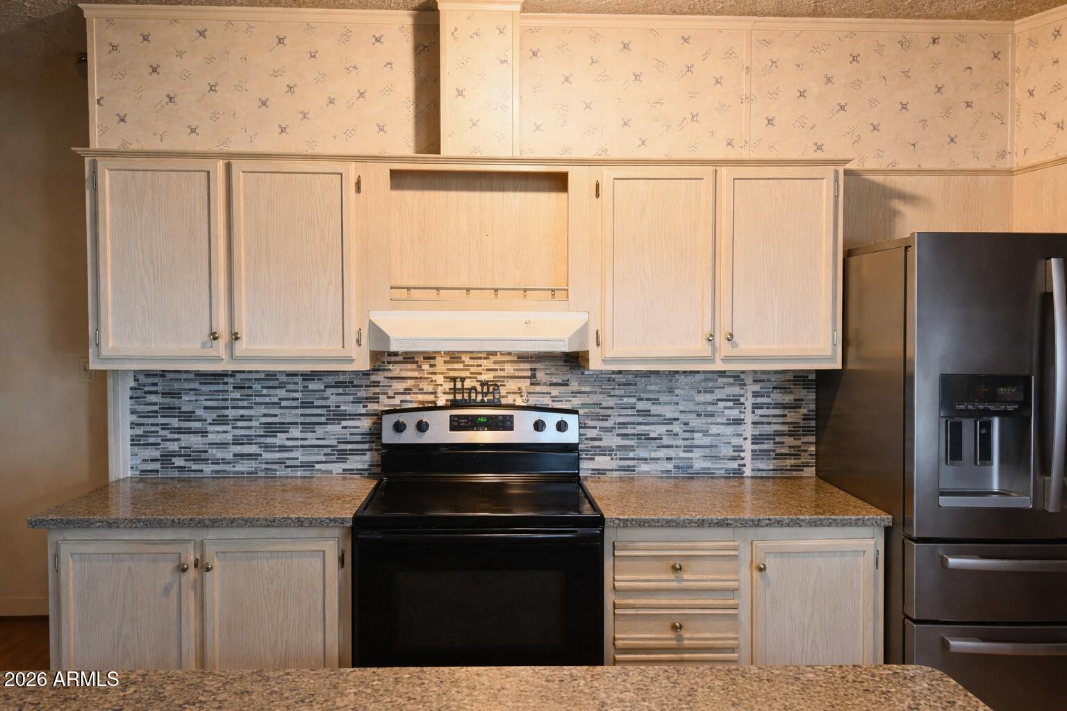3700 South Tomahawk Road, Unit 99 Apache Junction, AZ 85119 - Photo 5 of 10 a kitchen with granite countertop white cabinets and black appliances