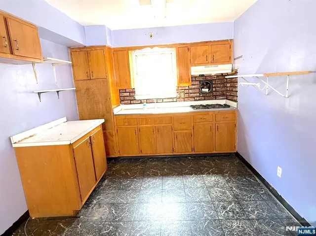 a kitchen with granite countertop a stove a sink and a microwave