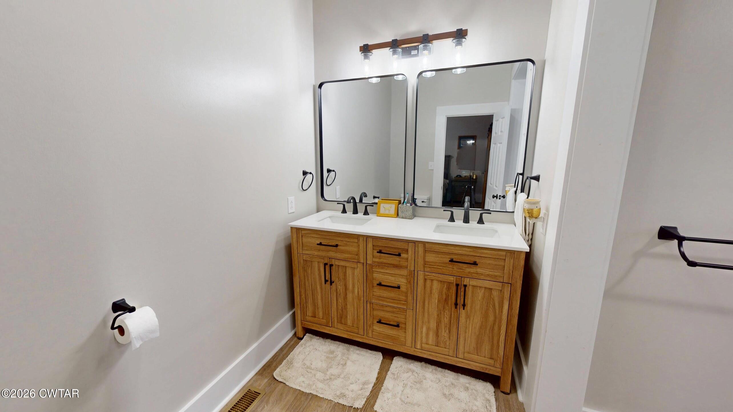 2800 Locust Grove Road Newbern, TN 38059 - Photo 25 of 46 a bathroom with a double vanity sink a mirror and a bathtub