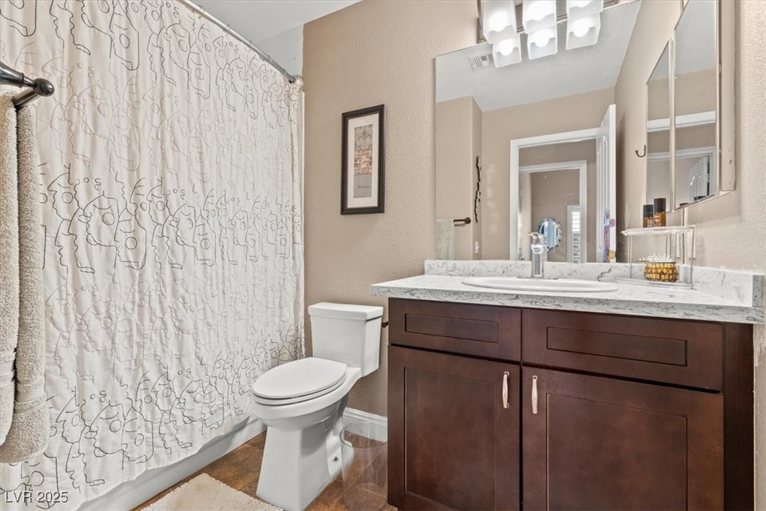 9031 West Viking Road Las Vegas, NV 89147 - Photo 24 of 33 Full bathroom featuring visible vents, baseboards, toilet, and vanity