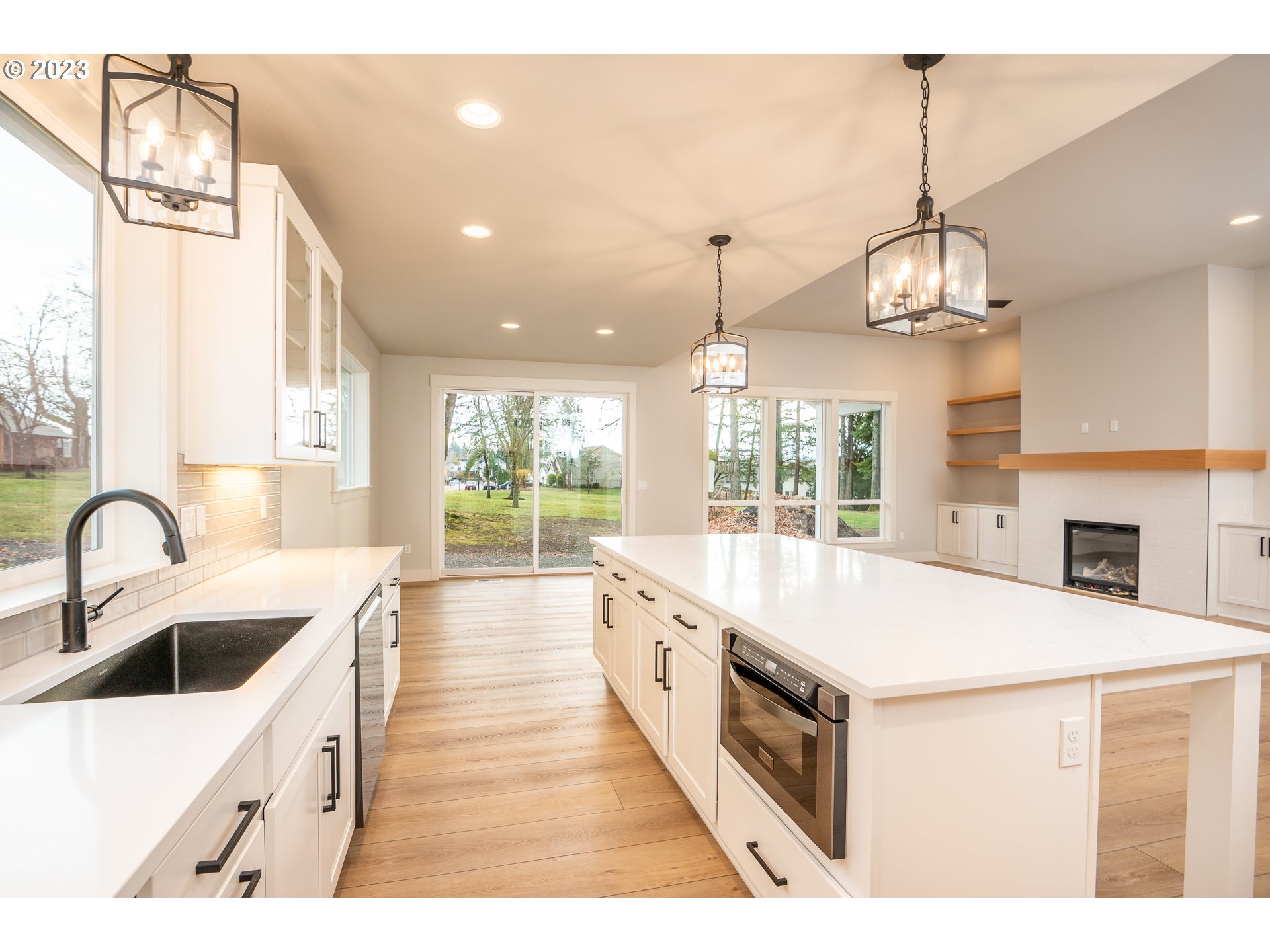 37772 Southeast Olson Street Sandy, OR 97055 - Photo 19 of 32 a large white kitchen with a large island oven a stove a sink a chimney and a chandelier