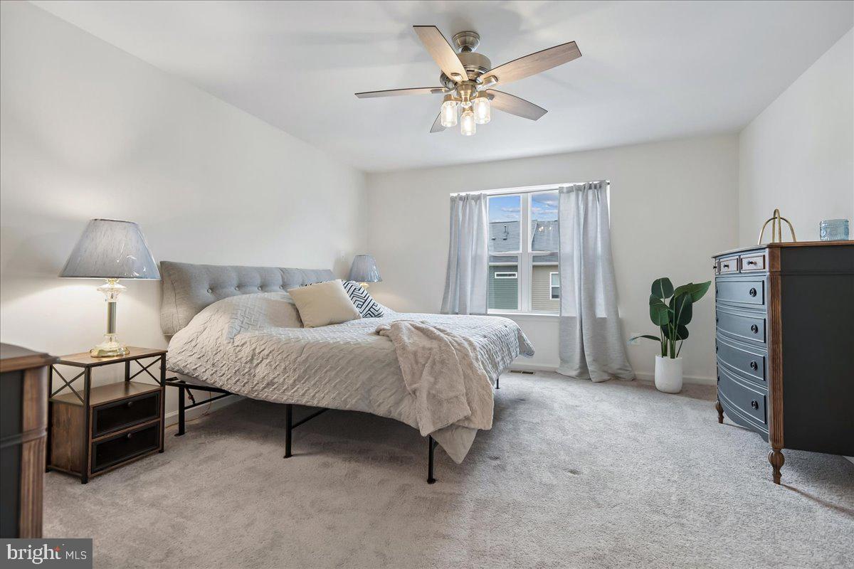 1813 Iris Lane Hanover, MD 21076 - Photo 14 of 20 a spacious bedroom with a bed a chandelier and a flat tv screen on a dresser
