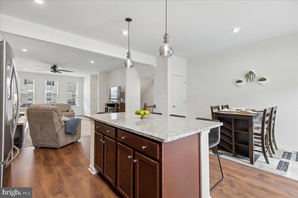 1813 Iris Lane Hanover, MD 21076 - Photo 6 of 20 a kitchen with a table chairs refrigerator and wooden floor