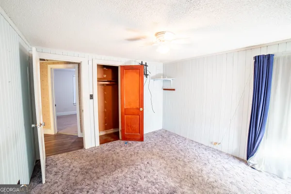 an empty room with closet and mirror