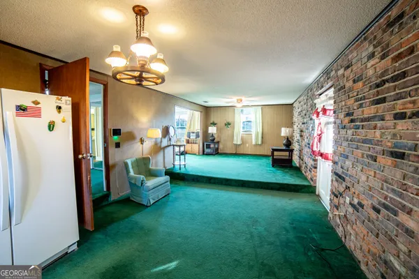 a view of a livingroom with furniture and a refrigerator
