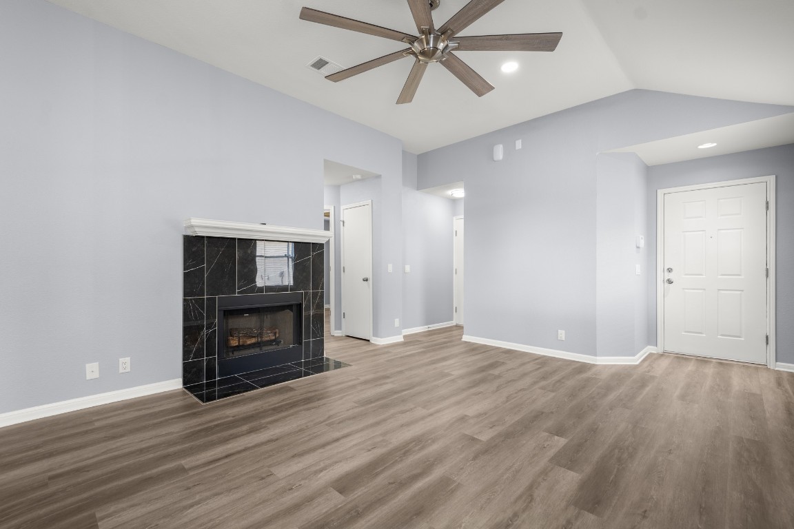 14303 Cummins Way Manor, TX 78653 - Photo 6 of 25 a view of a livingroom with a wooden floor and a fireplace