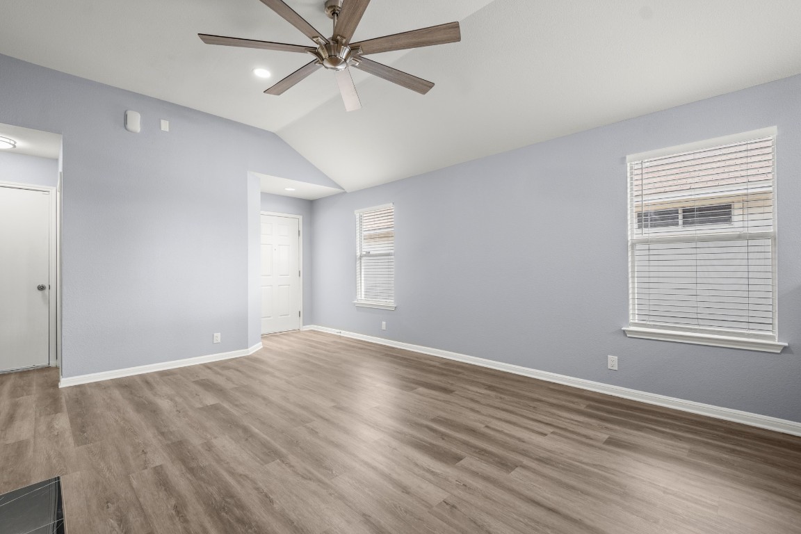 14303 Cummins Way Manor, TX 78653 - Photo 7 of 25 an empty room with wooden floor fan and windows