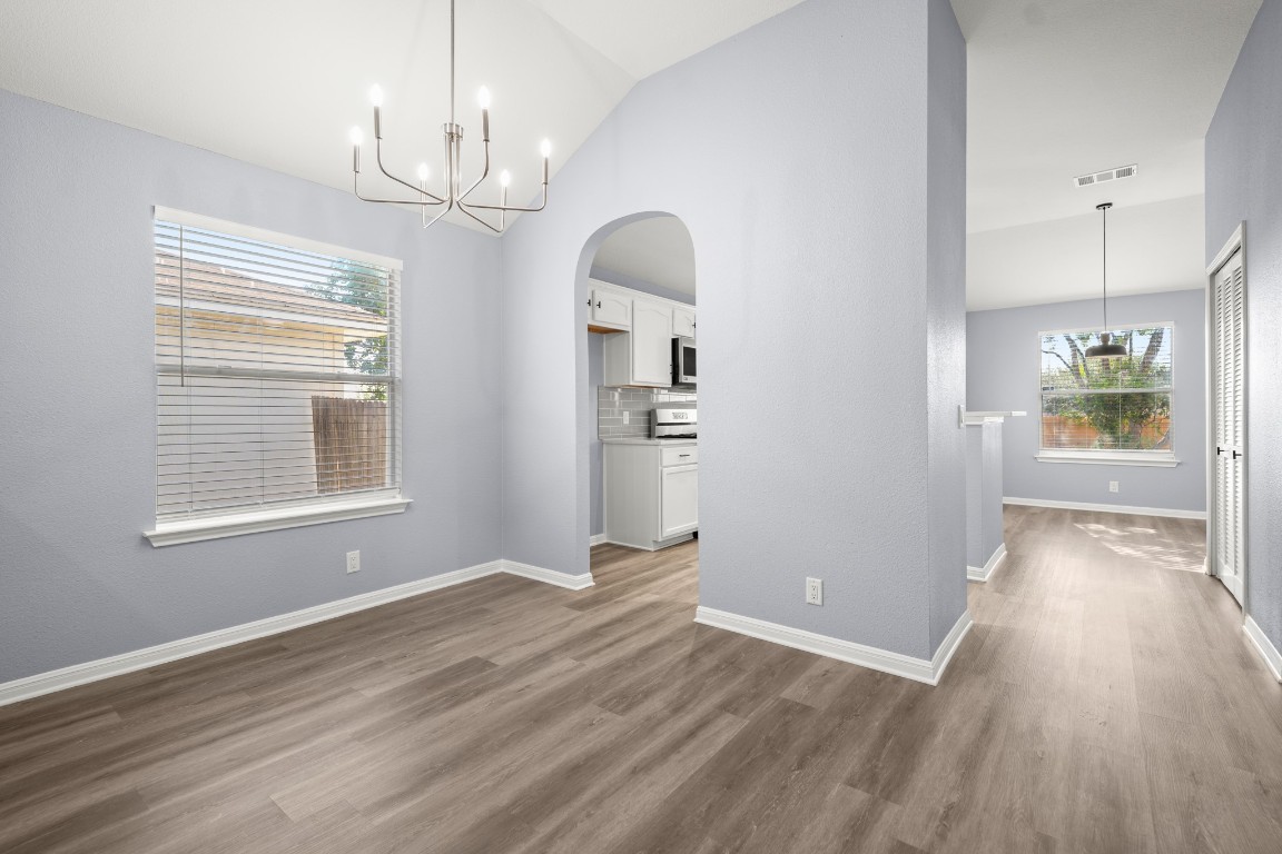 14303 Cummins Way Manor, TX 78653 - Photo 8 of 25 an empty room with wooden floor mirror and windows