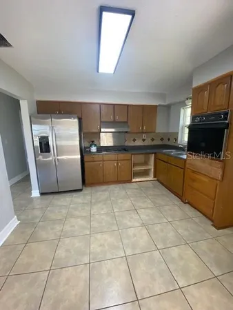a large kitchen with cabinets and steel appliances