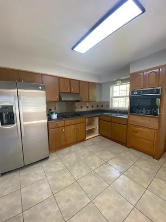 a kitchen with stainless steel appliances granite countertop a sink and a refrigerator
