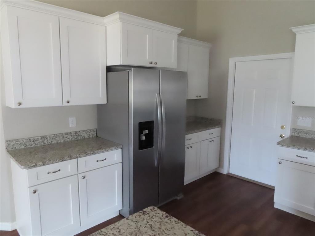 2501 Shirah Road Auburndale, FL 33823 - Photo 9 of 17 a kitchen with a sink dishwasher a refrigerator and white cabinets