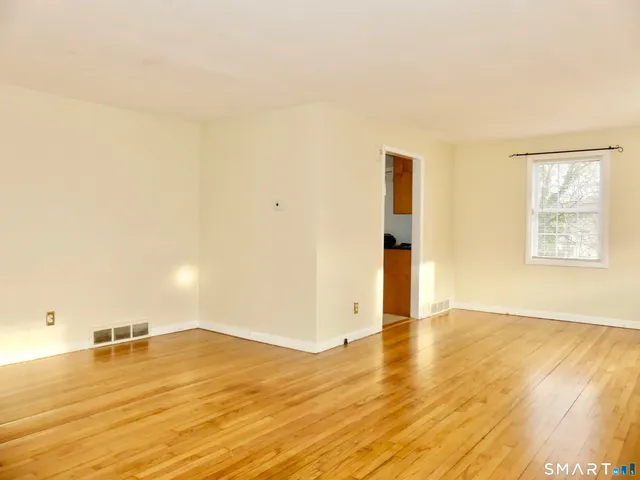 a view of empty room with wooden floor