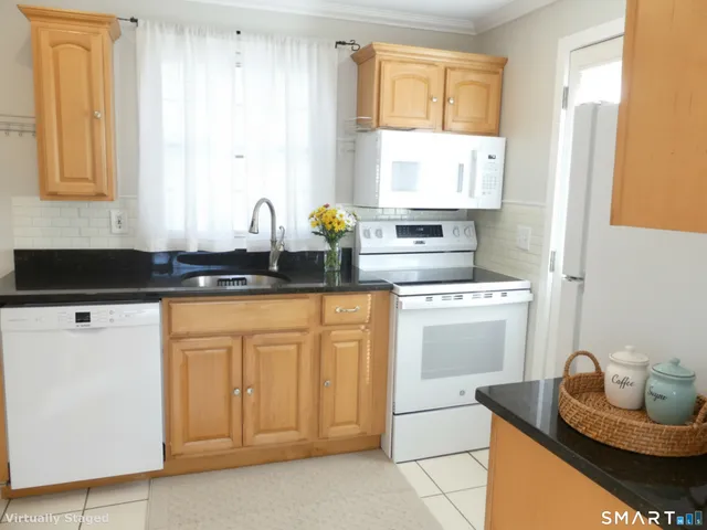 a kitchen with granite countertop white cabinets and sink