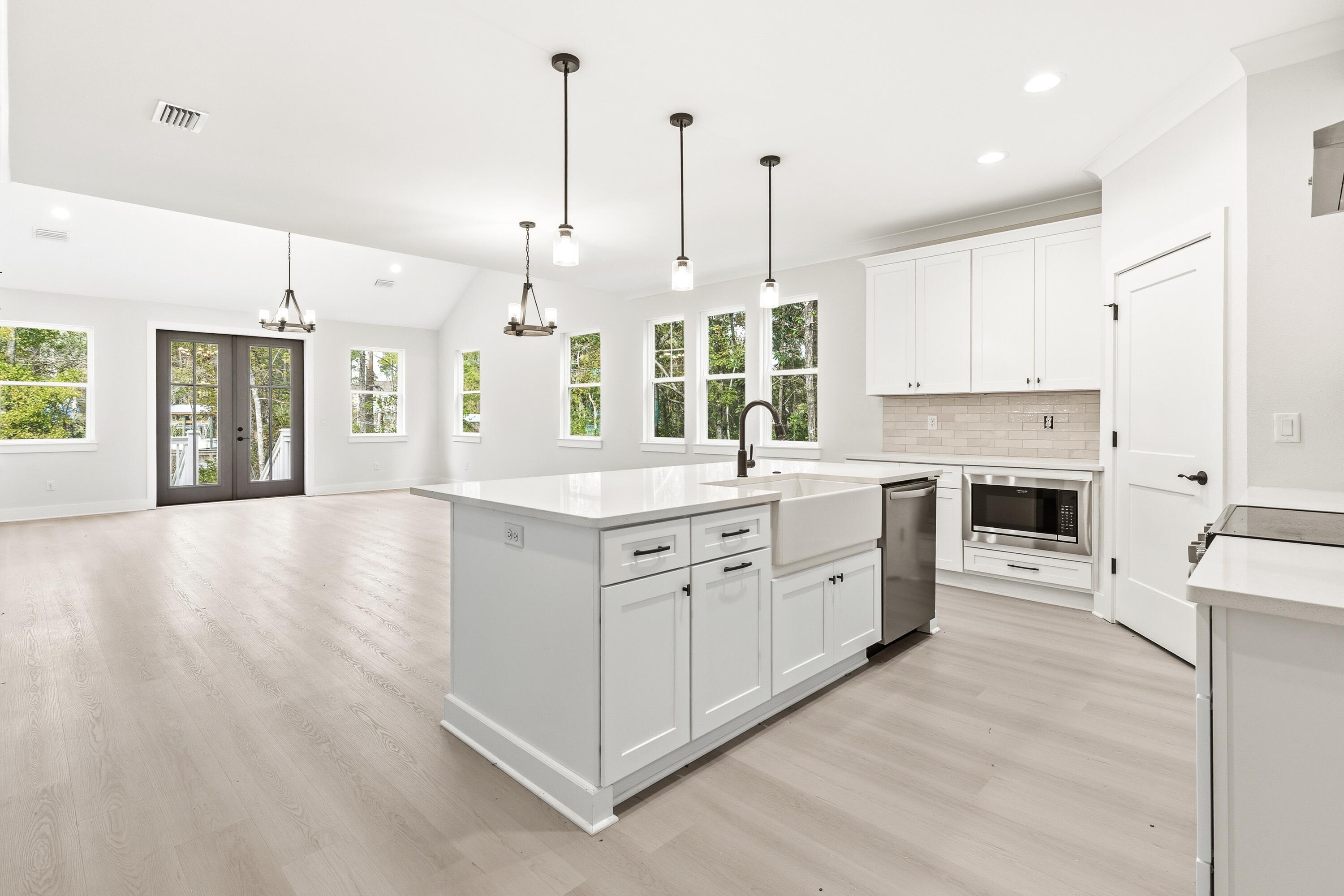 151 Redfish Pt Drive Freeport, FL 32439 - Photo 19 of 40 a large white kitchen with a large window a oven and stainless steel appliances