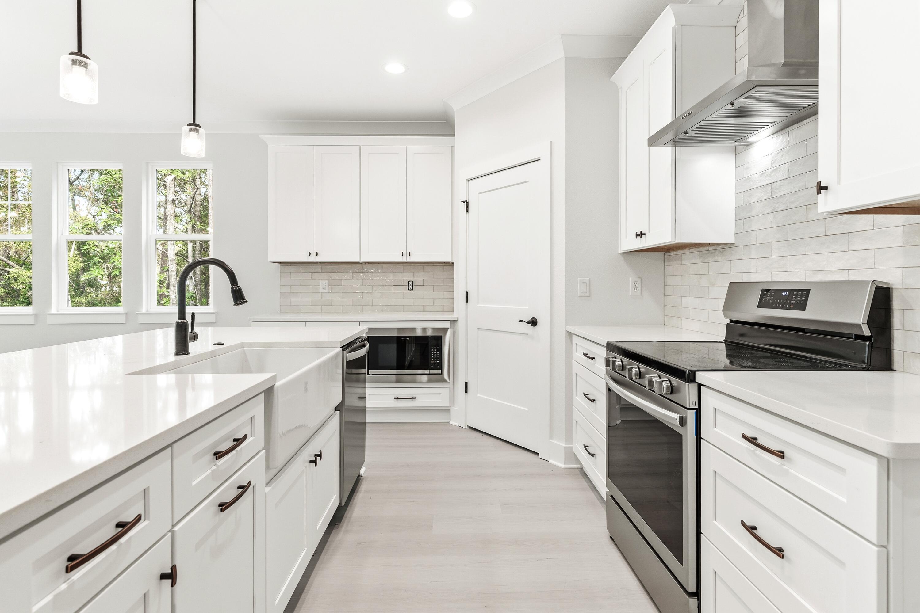 151 Redfish Pt Drive Freeport, FL 32439 - Photo 20 of 40 a kitchen with granite countertop a sink stainless steel appliances and white cabinets