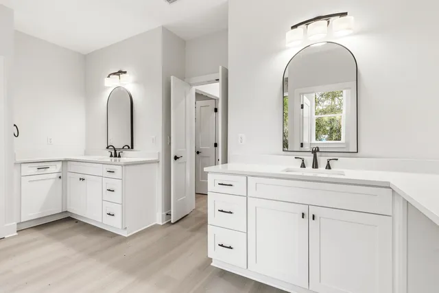 a bathroom with a double vanity sink mirror and a window