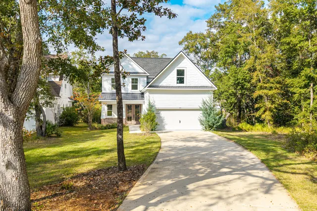 a front view of a house with a yard and trees