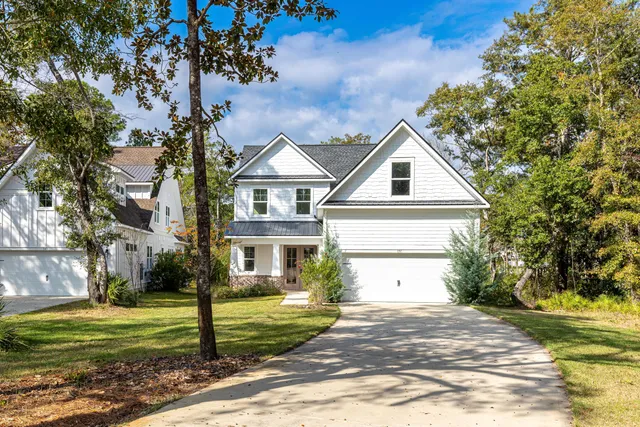 a front view of a house with a garden and trees
