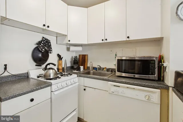a kitchen with a stove and a white cabinets