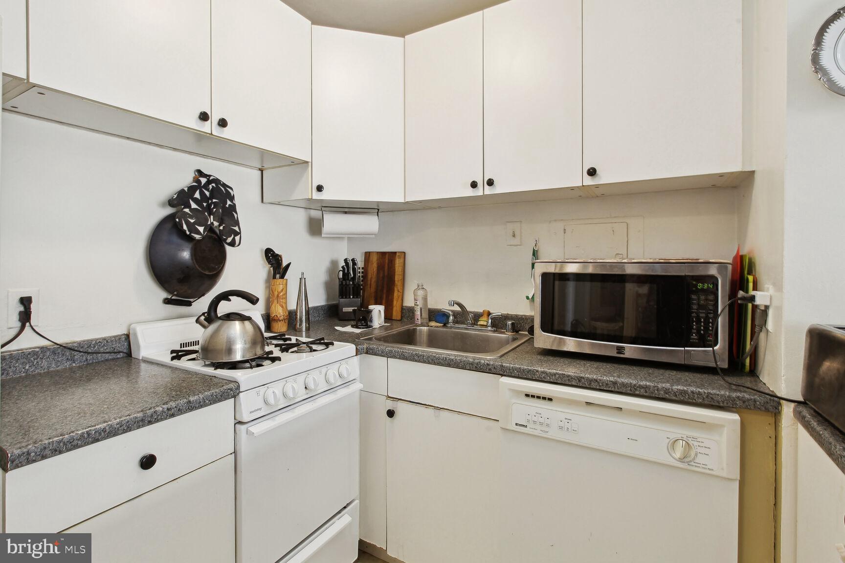 950 25th Street Northwest, Unit 608N Washington, DC 20037 - Photo 6 of 38 a kitchen with a stove and a white cabinets