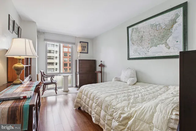 a bedroom with a bed a table and a flat screen tv