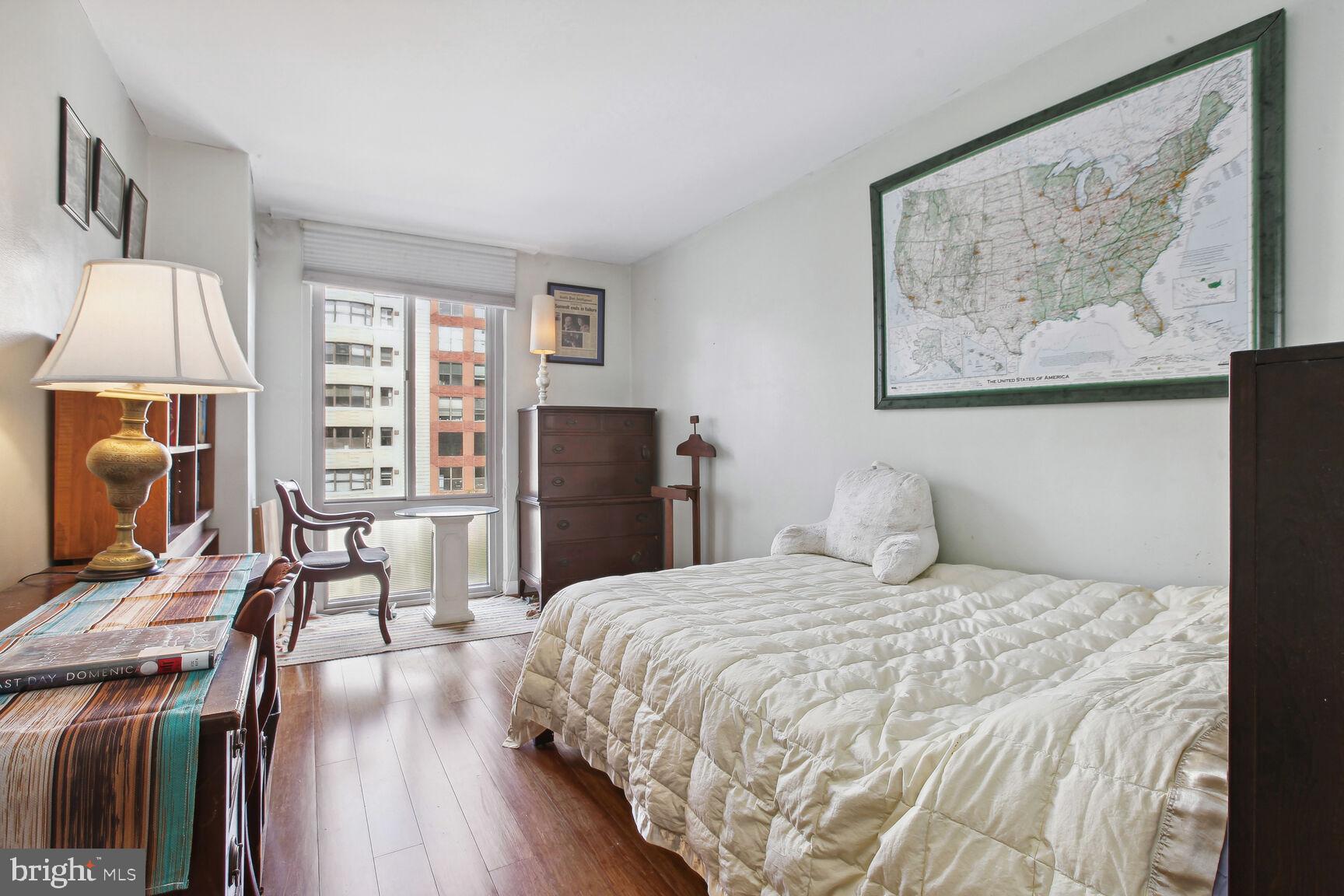 950 25th Street Northwest, Unit 608N Washington, DC 20037 - Photo 10 of 38 a bedroom with a bed a table and a flat screen tv