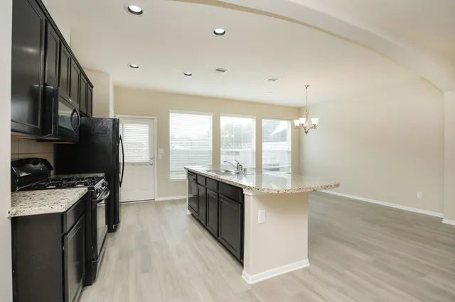 a kitchen with stainless steel appliances a stove top oven a sink and a refrigerator