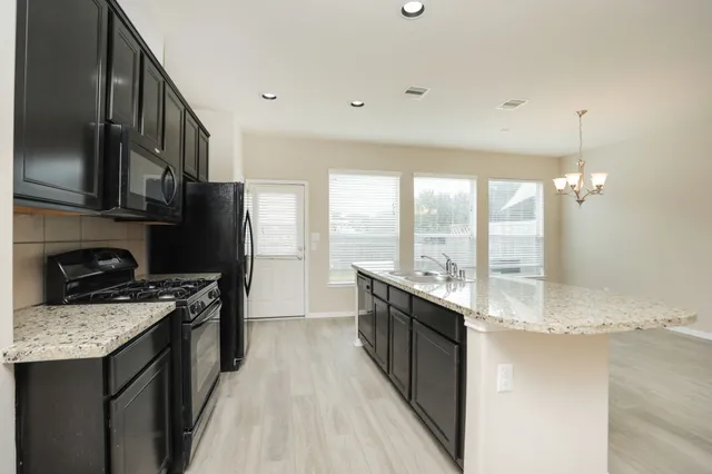 a kitchen with stainless steel appliances a stove sink and refrigerator