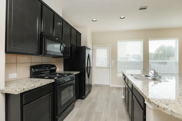 a kitchen with a stove a sink and a microwave